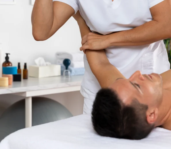 male patient performing physiotherapy exercises with female medic 595x516