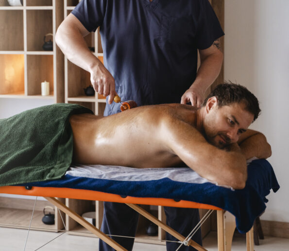 side view man getting professional massage 595x516